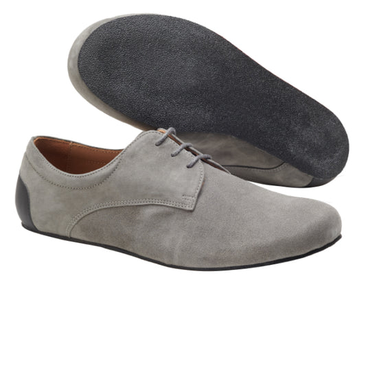 Hier ist eine Version des Satzes unter Verwendung der bereitgestellten Produktdaten:
Die Schuhe IQON Velours Grey von ZAQQ bestehen aus grauem Wildleder mit einer schwarzen Kautschuksohle aus Gummi. Ein Schuh ist aufrecht positioniert, um seine Schnürsenkel und die Seitenansicht hervorzuheben, während der andere das einzigartige Sohlendesign offenbart. Diese Schuhe vereinen perfekt Komfort und Stil und sind somit ein idealer Business-Barfußschuh für einen entspannten und dennoch professionellen Auftritt.