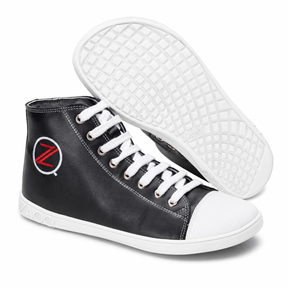 Le sneakers alte nere CHUQQS di ZAQQ hanno suole e lacci bianchi, rinforzati da una punta bianca. Sul lato si vede un logo con una Z rossa in un cerchio bianco. La suola in caucciù è progettata con un motivo a griglia per migliorare aderenza e durabilità.