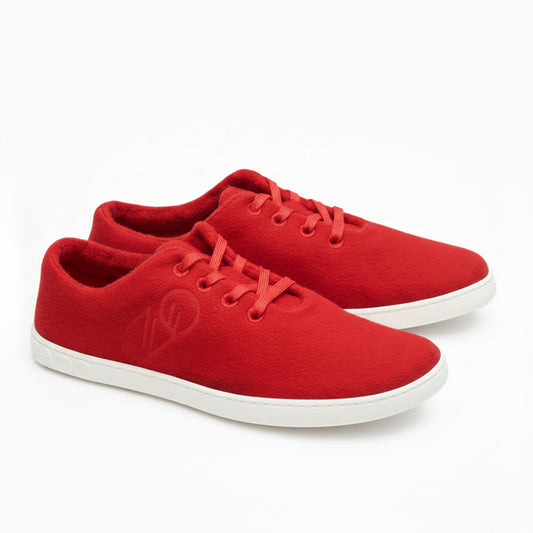 Ausgestellt wird ein Paar LIQE Race Sneaker von ZAQQ aus leuchtend roter Merinowolle mit grauer Sohle. Diese Sneaker kommen mit roten Schnürsenkeln und dezenter Stickerei an der Seite. Die Barfußsohle zeigt das Logo der Marke in Kontrastfarbe.