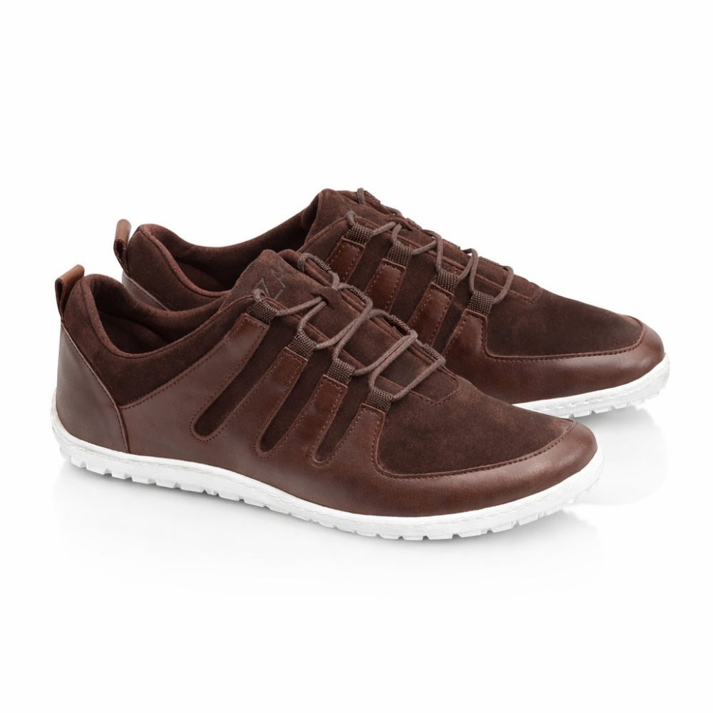 Wir präsentieren die SHOQQ Dark Brown Sneaker von ZAQQ, eine schicke Kombination aus braunem Leder und Wildleder, ergänzt durch weiße Gummisohlen. Diese lässigen Barfußschuh-Sneaker verfügen über ein Schnürdesign und werden kunstvoll vor einem sauberen weißen Hintergrund in Szene gesetzt.
