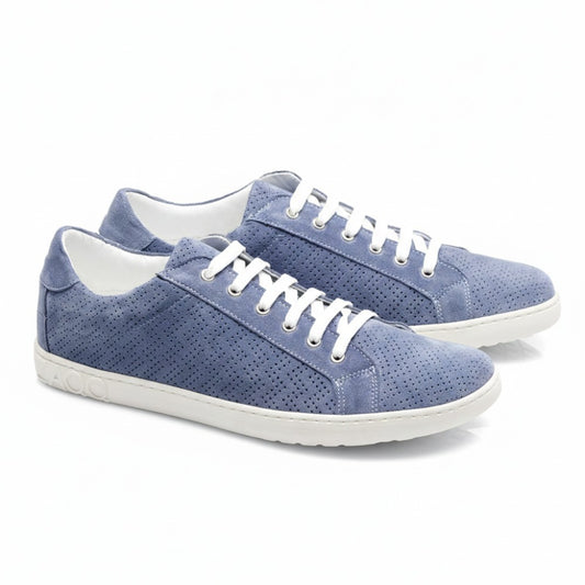 Die SLOQ Blue Sneaker von ZAQQ sind aus hellblauem Veloursleder gefertigt und verfügen über weiße Schnürsenkel sowie ein perforiertes Design. Die Sohlen weisen ein strukturiertes Muster auf, während das Logo der Marke elegant auf der Ferse eingeprägt ist und sich von einem makellos weißen Hintergrund abhebt.