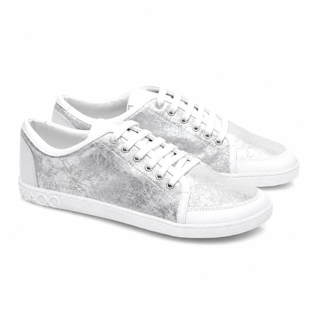 Presentiamo le TIQQ Silver White di ZAQQ: un paio di sneaker eleganti in pregiata nappa con una texture metallica argentata e suole bianche. Queste sneaker sono dotate di lacci bianchi brillanti, cuciture decorative e un dettaglio distintivo 4000 sul lato della suola.