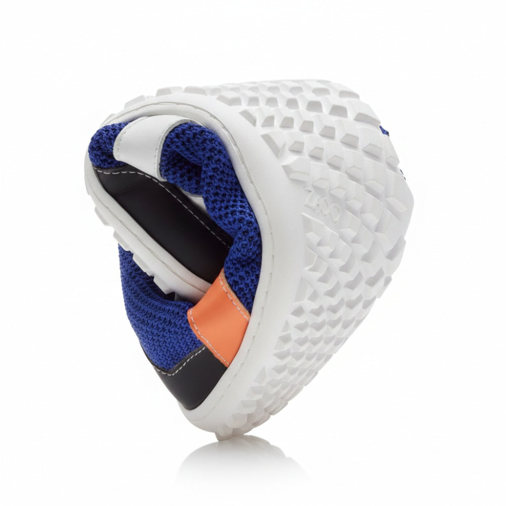 Der ZARQA Blue von ZAQQ zeigt seine extreme Flexibilität. Er lässt sich in der Mitte biegen und gibt eine schwarze strukturierte Sohle und ein blaues Mesh-Obermaterial frei. Der Schuh ist mit orangefarbenen und schwarzen Details akzentuiert, die seine Beweglichkeit und Atmungsaktivität vor einem weißen Hintergrund betonen.